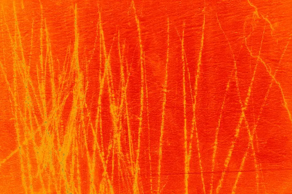 Dynamic abstract pattern in orange and yellow with a textured, scratched surface.